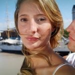 A women looking slightly away from a guy that wants to hug her.