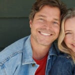 Woman and man over 50 smiling into camera as a couple