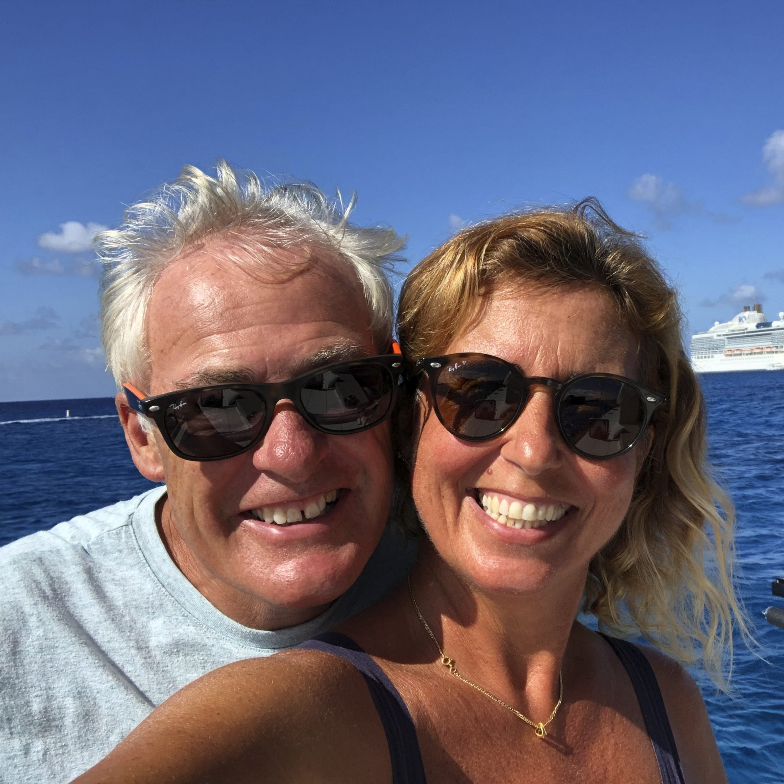 A middle aged couple smiling happily into the camera - eharmony success story