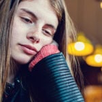 Man sits on bench facing away from woman as sign that he is not into you