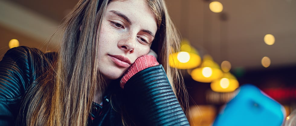 Man sits on bench facing away from woman as sign that he is not into you