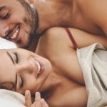 A young couple being playful in bed in the morning