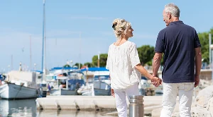 A couple walking hand in hand at the harbour.