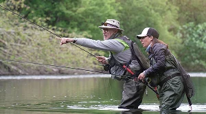 A couple fishing on a date at a lake with gear.