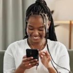 Women looking on a phone smiling learn how to ask someone out over text