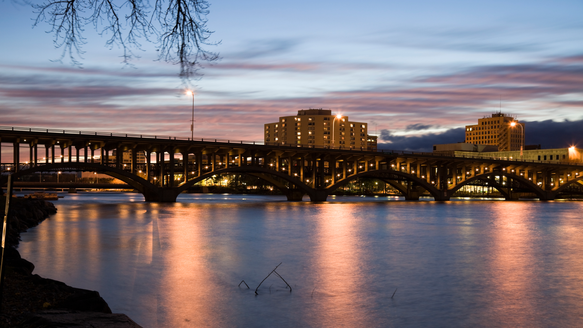 Skyline view of Rockford with water and a bridge in the foreground.